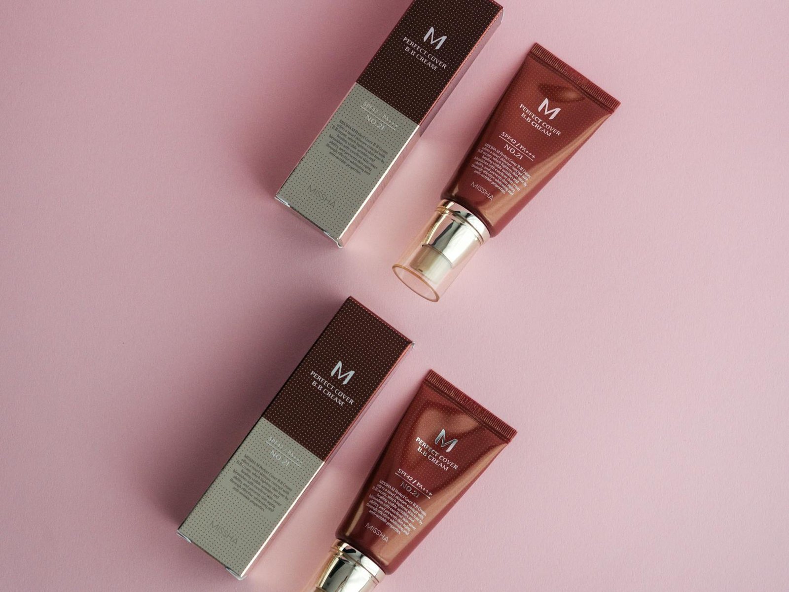 missha cosmetic products on a pink surface